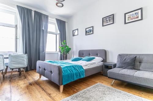ein Schlafzimmer mit einem Bett und einem Sofa in der Unterkunft Stylish 1BR Apartment- Near Westbahnhof U3&U6 in Wien