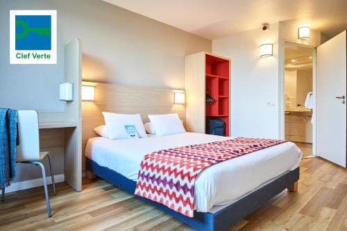 a hotel room with a bed and a desk at Kyriad Rouen Sud - Val de Reuil in Val de Reuil