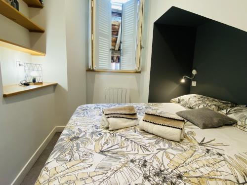 Un dormitorio con una cama grande con cabecero negro. en Chez PISTACHE, en Rodez