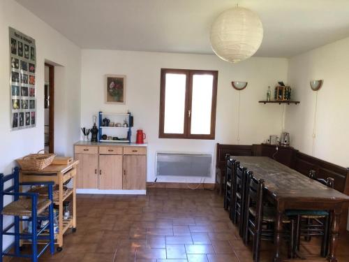 a kitchen with a table and some chairs and a counter at Grand chalet familial in Forest-Saint-Julien