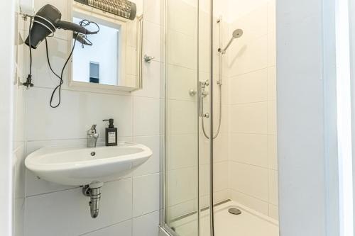 ein Bad mit einem Waschbecken und einer Dusche in der Unterkunft Stylish 1BR Apartment- Near Westbahnhof U3&U6 in Wien