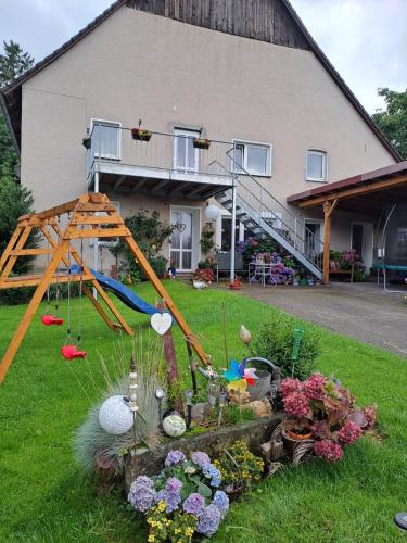 a garden in front of a house with a playground at Ferienhof Welling in Horn-Bad Meinberg