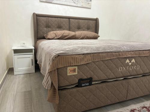 ein Bett mit brauner Bettdecke in einem Schlafzimmer in der Unterkunft Petar Apartment in Podgorica