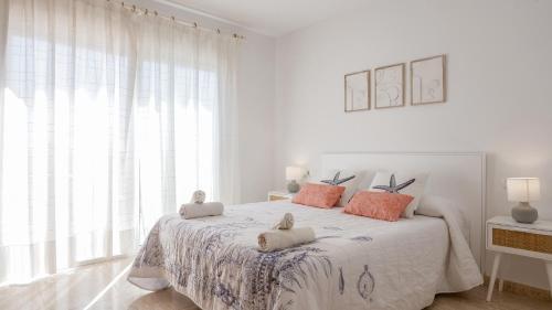 a white bedroom with a bed with two stuffed animals on it at Casa Mar con piscina privada AA y Wi-Fi delante del mar. in Vinaròs