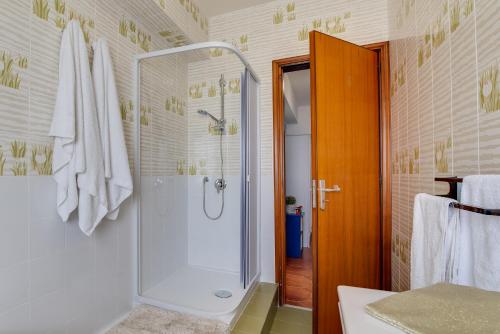 een badkamer met een douche en een glazen deur bij A'Mari - Holiday Home - Sciacca in Sciacca