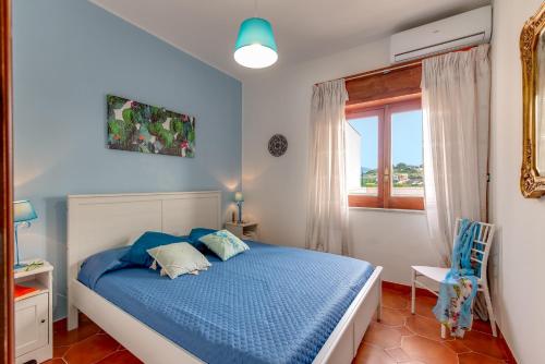 een slaapkamer met een blauw bed en een raam bij A'Mari - Holiday Home - Sciacca in Sciacca
