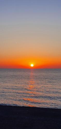 a sunset on the beach with the sun setting at Casa vacanza le Ancore in Barcellona-Pozzo di Gotto