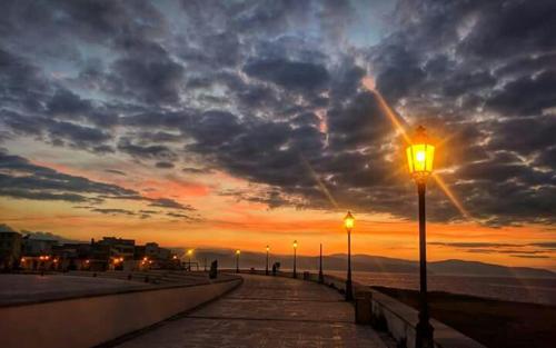 a street light on a pier at sunset at Casa vacanza le Ancore in Barcellona-Pozzo di Gotto