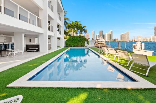 een zwembad in de achtertuin van een gebouw met stoelen bij Villa Milli in Miami