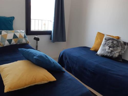 - une chambre avec 2 lits et un oreiller pour chat dans l'établissement Gîte de charme au Paradou. Piscine. Terrasse bois., à Paradou