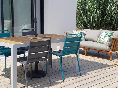un patio avec une table, des chaises et un canapé dans l'établissement Gîte de charme au Paradou. Piscine. Terrasse bois., à Paradou