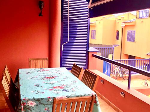 uma mesa e cadeiras numa varanda com uma mesa e uma janela em Beach and golf 4 Bedroom Holiday Home em Maspalomas