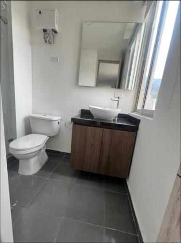 een badkamer met een toilet, een wastafel en een spiegel bij Loft en Monserrate in Bogota