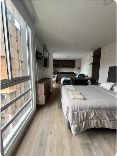 een slaapkamer met een bed en een groot raam bij Loft en Monserrate in Bogota