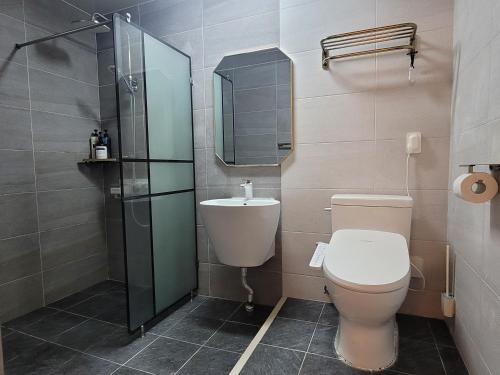 a bathroom with a toilet and a shower and a sink at Green Casa in Hwasul-li