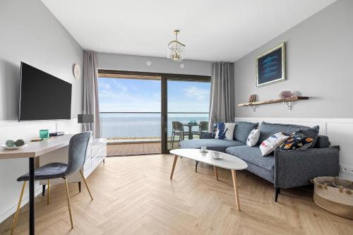 a living room with a couch and a table at Solaris Darłówko Premium Emilia Strupiechowska in Darłowo