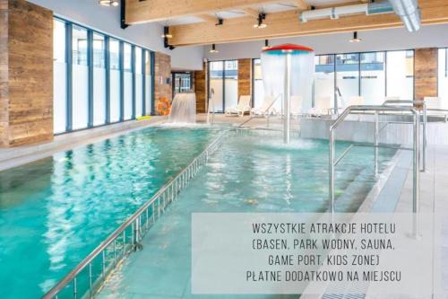 a large swimming pool in a building with a sign at HOLIDAY HOME Bel Mare 522F z balkonem in Międzyzdroje
