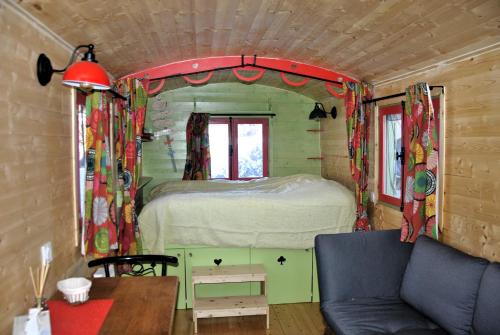 - une petite chambre avec un lit dans une petite maison dans l'établissement Chambre d'hôte dans Roulotte aménagée tout confort Kitchenette SDB La Fée Favie, à Villy-le-Bouveret