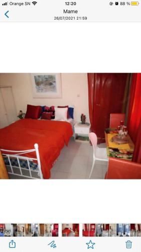 1 dormitorio con 1 cama con manta roja en Chez penda, en Dakar