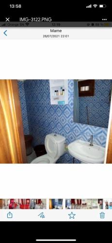 a bathroom with a white toilet and a sink at Chez penda in Dakar