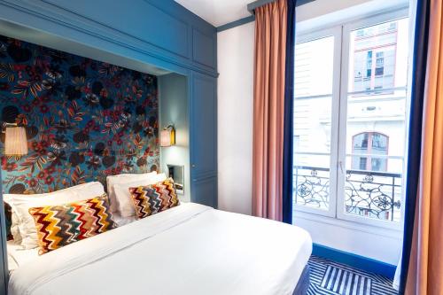 a bedroom with a large bed with a window at Hotel de Fleurie - Saint-Germain-des-Pres in Paris