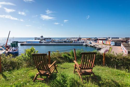 two chairs sitting on the grass near the water at Hotel Rickmers' Insulaner in Helgoland