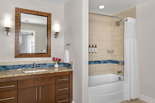 a bathroom with a tub and a sink and a mirror at Marriott's Crystal Shores in Marco Island