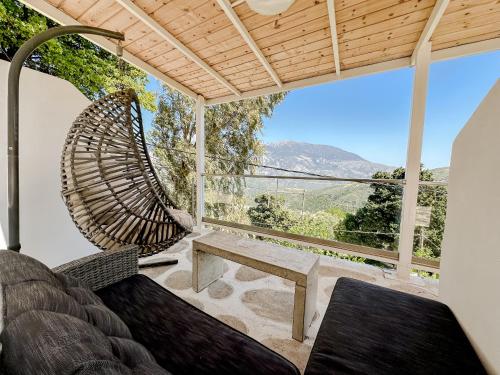 a porch with a bench and a swing at Mountain Bliss Guesthouse 2 next to Sougia in Agrilés