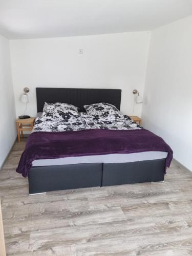 a bedroom with a bed with a purple comforter at Ferienhaus Toni im Stadtkern von Bremervörde in Bremervörde