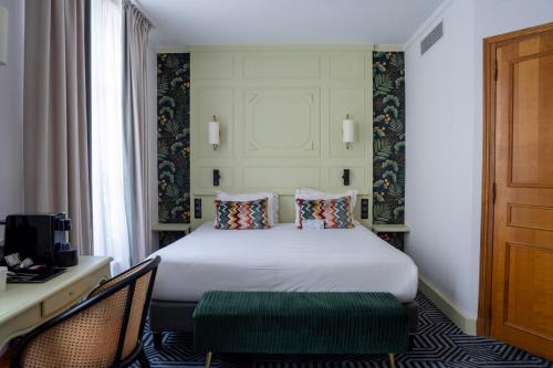 a hotel room with a bed and a table and chairs at Hotel de Fleurie - Saint-Germain-des-Pres in Paris