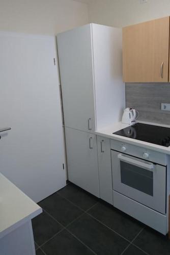 a kitchen with white cabinets and a stove at Ferienhaus Toni im Stadtkern von Bremervörde in Bremervörde