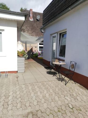 a patio with a table and chairs next to a house at Ferienhaus Toni im Stadtkern von Bremervörde in Bremervörde