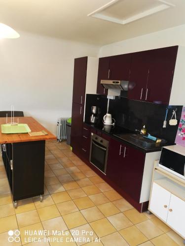 une cuisine avec des armoires marron et un comptoir dans l'établissement Les Dunes Blanches, à Saint-Étienne-au-Mont