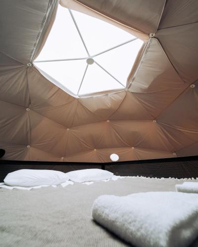 a bed in a tent with a large window at Golden Circle Domes - Lake View in Selfoss
