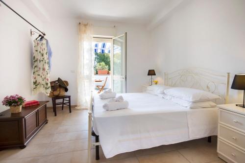 Un dormitorio blanco con una cama grande y una ventana en Casa Acquamarina - comfort e relax a pochi passi dalle spiagge del Salento, en Lido Marini