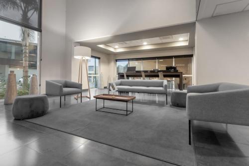 uma sala de estar com sofás e uma mesa de centro em City Express by Marriott Celaya Galerias em Celaya