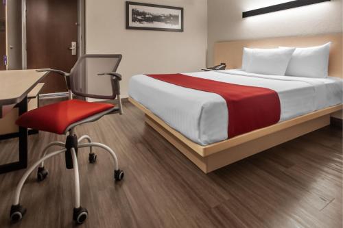 a bedroom with a bed and a desk and a chair at City Express by Marriott Celaya Galerias in Celaya