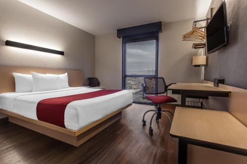 a hotel room with a bed and a desk at City Express by Marriott Celaya Galerias in Celaya