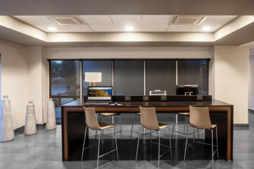 a kitchen with a bar with chairs and a desk at City Express by Marriott Celaya Galerias in Celaya