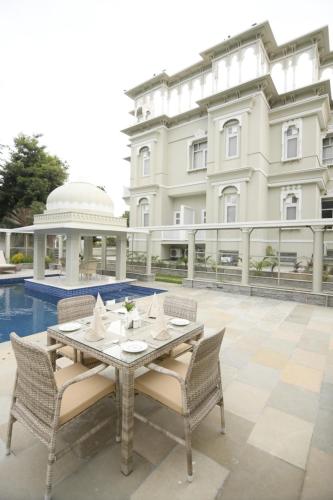 una mesa y sillas frente a un edificio en The Tiger Villa by ATD India - Group of Hotels and Resorts, en Sawāi Mādhopur