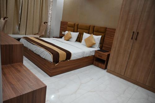 a bedroom with a large bed with a wooden headboard at Hotel Navraj Palace in Gomti Nagar