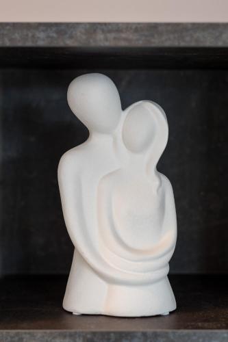 a white sculpture of two people sitting on a table at Castelia Luxury Villas in Agios Ioannis