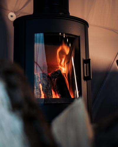 a stove with a fire in it at Golden Circle Domes - Lake View in Selfoss