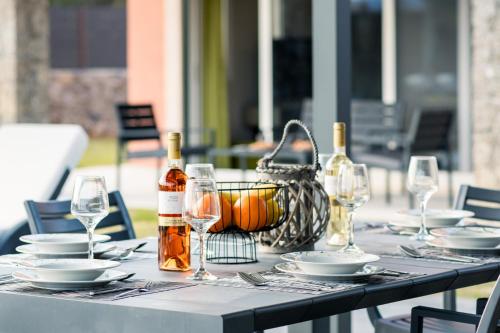 a table with glasses and bottles of wine on it at Castelia Luxury Villas in Agios Ioannis