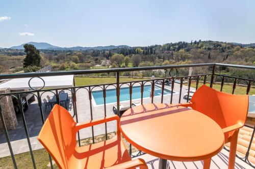a balcony with a table and chairs and a pool at Castelia Luxury Villas in Agios Ioannis