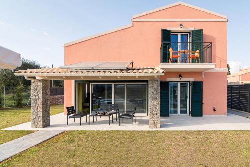 a house with a table and chairs on a patio at Castelia Luxury Villas in Agios Ioannis