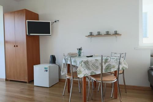 科沃布热格Willa Świerkowa的餐桌、椅子和墙上的电视