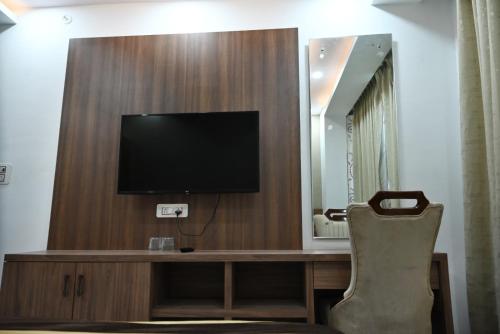a room with a tv and a desk with a chair at Hotel Navraj Palace in Gomti Nagar
