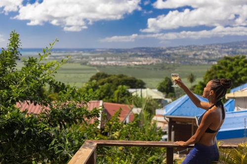 a woman is holding a glass of wine at Chalet étoilé BAYALOCATION in Le Lamentin