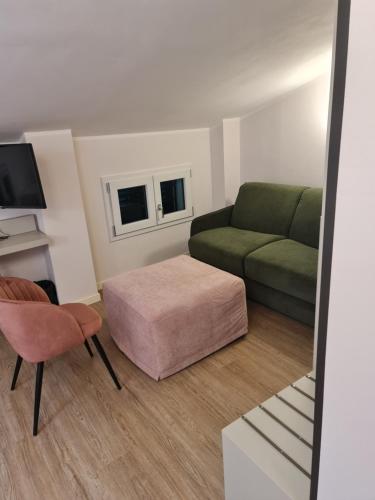 ein Wohnzimmer mit einer grünen Couch und einem Stuhl in der Unterkunft Hotel Miratorre superior in Pisa